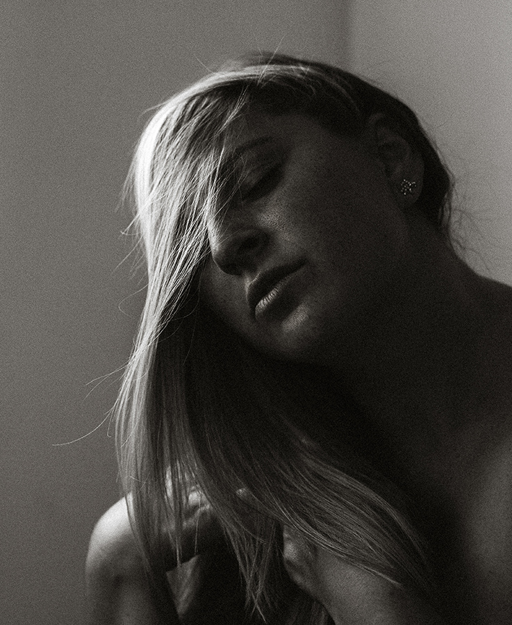 blonde woman with hair covering half her face has eyes closed in an intimate portrait of RAW beauty as part of Emily Brault Boudoir's RAW Project.
